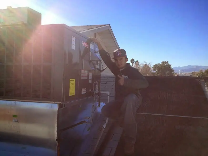 HVAC technician performing Air Duct Repair on a rooftop unit in Lake Tapps